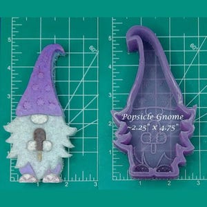 Könnte beinhalten: Lilafarbene Silikonform eines Gnoms, der ein Eis am Stiel hält. Die Form ist 2,25 Zoll mal 4,75 Zoll groß. Der Gnom trägt einen lila Hut und hat einen weißen Bart.