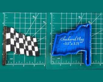 May include: A blue silicone mold for making a checkered flag cake topper. The mold is 3.5 inches by 3.75 inches.