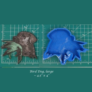 May include: A blue silicone mold of a bird dog with a bird in its mouth. The mold is approximately 4.5 inches by 4 inches.