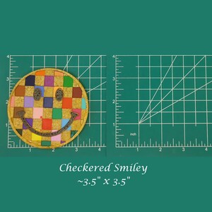 May include: A colorful checkered smiley face patch, approximately 3.5 inches by 3.5 inches. The patch is made of fabric and has a checkered pattern in various colors, including red, yellow, blue, green, and purple. The smiley face is outlined in black and has a white outline around the eyes and mouth.