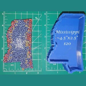 May include: A blue silicone mold of the state of Mississippi. The mold is approximately 4.5 inches by 2.5 inches. The text "Mississippi ~4.5" x 2.5" $20" is printed on the mold.