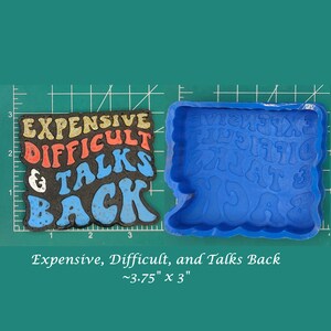 May include: A blue silicone mold for making resin crafts. The mold is shaped like the words "Expensive, Difficult, and Talks Back" in a retro font. The mold is approximately 3.75 inches by 3 inches.