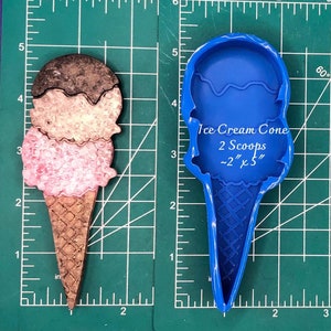 以下が含まれることがあります： 約5cm×13cmのアイスクリームコーン型の工芸品。画像には、「Ice Cream Cone 2 Scoops ~2" x 5"」というテキストが入った、青いプラスチック製のアイスクリームコーン型の型も写っています。