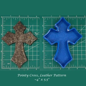 May include: A blue silicone mold of a pointy cross with a leather pattern. The mold is approximately 4 inches by 5.5 inches.