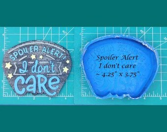 May include: A blue silicone mold for resin casting. The mold is shaped like a speech bubble and has the text "Spoiler Alert I don't care" and "~4.25" x 3.75" written on it.
