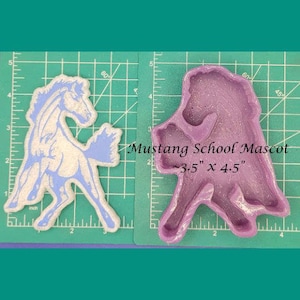 Op de afbeelding: Een paarse siliconen mal van een opspringend paard, ongeveer 8,9 cm bij 11,4 cm, op een groene snijmat. De tekst "Mustang School Mascot" is boven de mal gedrukt.