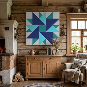 Può includere: Un'opera d'arte da parete quadrata con un motivo geometrico a stella in tonalità blu navy, verde acqua e azzurro. Il design è composto da triangoli e quadrati disposti in un motivo a stella simmetrico a più punte su uno sfondo bianco.