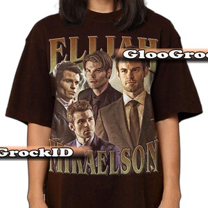 K&ouml;nnte beinhalten: Braunes T-Shirt mit einem Retro-Design, das vier M&auml;nner und den Text "ELIJAH MIKAELSON" in Gold zeigt. Die Grafik hat ein abgenutztes, gealtertes Aussehen.