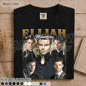 May include: Black t-shirt with a gold graphic of Elijah Mikaelson and the text "Elijah Mikaelson". The design includes multiple images of the character and lightning bolt graphics. Available in various colours.