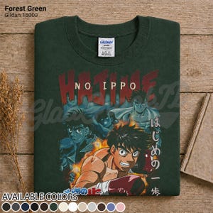 Op de afbeelding: Een bosgroen t-shirt met ronde hals en een grafische print van de anime Hajime no Ippo. Het ontwerp toont meerdere personages in bokshoudingen met vlammen en de tekst Hajime No Ippo in rood en wit. Een Gildan 18000 label is zichtbaar.