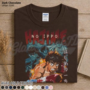Op de afbeelding: Een donker chocoladebruin T-shirt met korte mouwen en een grafische print van de anime Hajime No Ippo. Het ontwerp toont meerdere personages in bokshoudingen, vlammen, de tekst Hajime No Ippo in het rood en Japanse tekens in het wit.