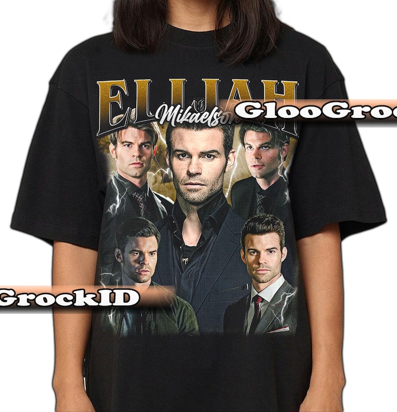 May include: Black t-shirt with a collage of images of a man and the text "Elijah Mikaelson" in gold lettering. The design includes lightning bolt graphics and a vintage aesthetic.