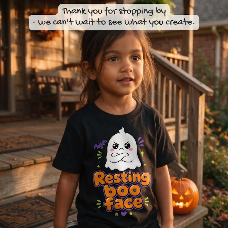 May include: A black t-shirt featuring a white cartoon ghost with a grumpy expression and crossed arms. Below the ghost, the text reads 'Resting boo face' in orange and purple letters, surrounded by small purple bats and yellow stars.