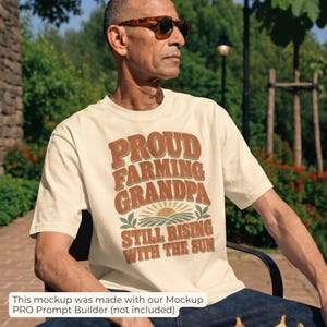 May include: A cream-colored short-sleeve t-shirt featuring the text PROUD FARMING GRANDPA STILL RISING WITH THE SUN in brown and orange letters, with a graphic of a rising sun over a field of crops centered on the chest.