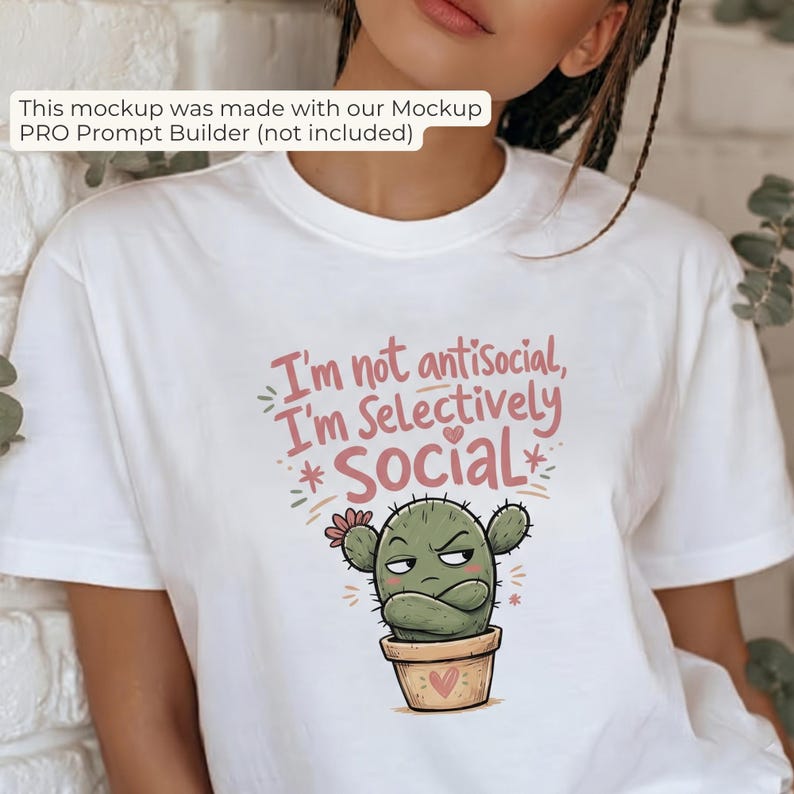 May include: A white short-sleeved t-shirt featuring a graphic of a grumpy green cactus in a tan pot with arms crossed. The text above the cactus reads, "I'm not antisocial, I'm Selectively Social" in pink and brown lettering with small hearts.
