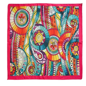 May include: A square pink patterned scarf with a colorful abstract design featuring circles, swirls, and geometric shapes in shades of orange, yellow, blue, green, and purple.