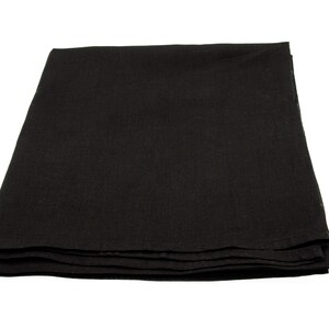 May include: A folded, black linen tablecloth. The fabric appears to be a solid color with a slightly textured surface. The tablecloth is neatly folded, with visible layers.