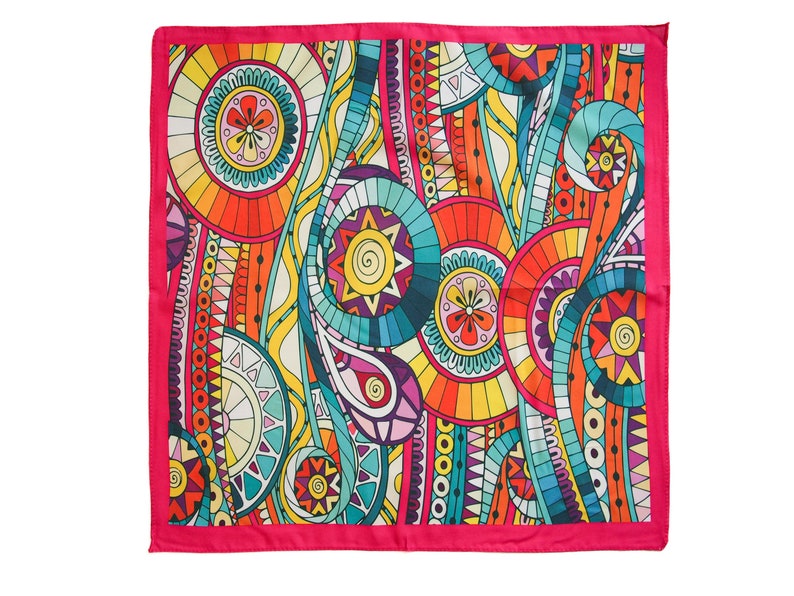 May include: A square pink patterned scarf with a colorful abstract design featuring circles, swirls, and geometric shapes in shades of orange, yellow, blue, green, and purple.