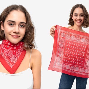 Può includere: Bandana rossa con motivo paisley bianco. La sciarpa quadrata viene mostrata, mettendo in risalto il design. La bandana è indossata intorno al collo in un'altra immagine. Questo accessorio è versatile.