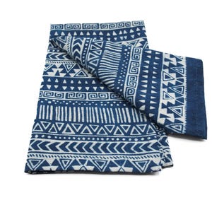 Pode incluir: Uma toalha de chá de algodão azul e branco com um design geométrico. A toalha está dobrada ao meio e o padrão é visível em ambos os lados.