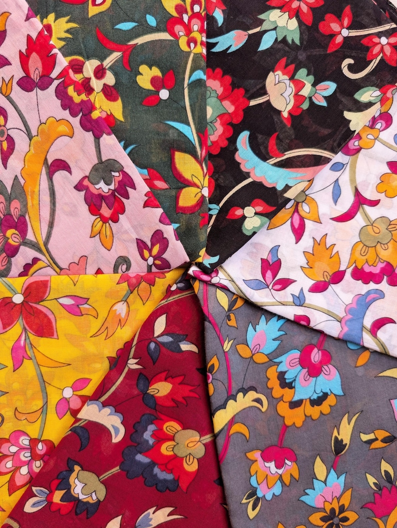 May include: A collection of colorful floral fabric swatches. The fabrics feature intricate designs with red, yellow, pink, and blue flowers on various backgrounds, including black, gray, and burgundy.