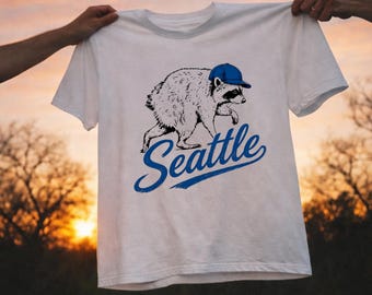 jimothy Baseball Raccoon Shirt, Seattle Sports Fan T-Shirt, Funny Seattle Raccoon Graphic Tee, Vintage Seattle Mascot Shirt, PNW Baseball.