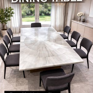 May include: A rectangular selenite stone dining table with a radial pattern, surrounded by eight grey upholstered chairs. The table has a gold base and is set on a light grey rug. Text at the top reads "SELENITE STONE DINING TABLE".