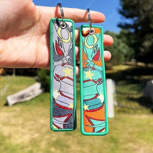 BUY 2 GET 3 - Dubbelzijdig geborduurde anime-sleutelhanger / sleutelhangers / Jet Tag