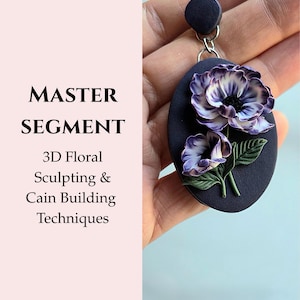以下が含まれることがあります： 紫と白の花と緑の葉の3Dフローラルデザインが施された、濃い青色の楕円形のペンダント。ペンダントは濃い青色の円形トップから吊り下げられています。左側のテキストは「MASTER SEGMENT」と「3D Floral Sculpting & Cain Building Techniques」です。
