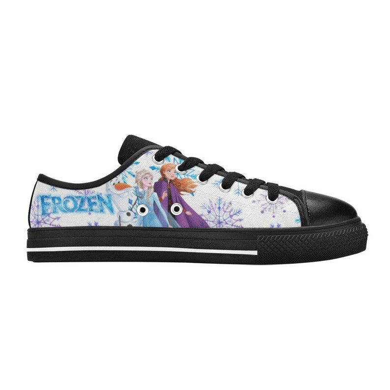 May include: Black canvas low-top sneakers with a white background featuring a graphic of Elsa and Anna from the movie Frozen. The text "FROZEN" is printed on the side of the shoe.