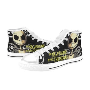 May include: High-top canvas sneakers featuring a black and white design with the character Jack Skellington from "The Nightmare Before Christmas." The shoes have white laces, a white toe cap, and the movie title printed on the side.
