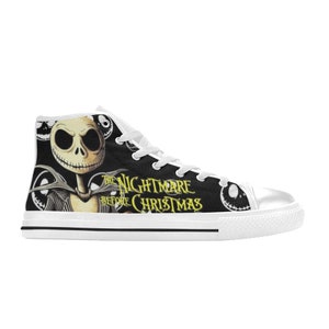 May include: High-top canvas sneakers featuring a black and white design with the text "The Nightmare Before Christmas." The sneakers showcase Jack Skellington's face and other characters from the movie. The shoes have white laces and a white rubber sole.