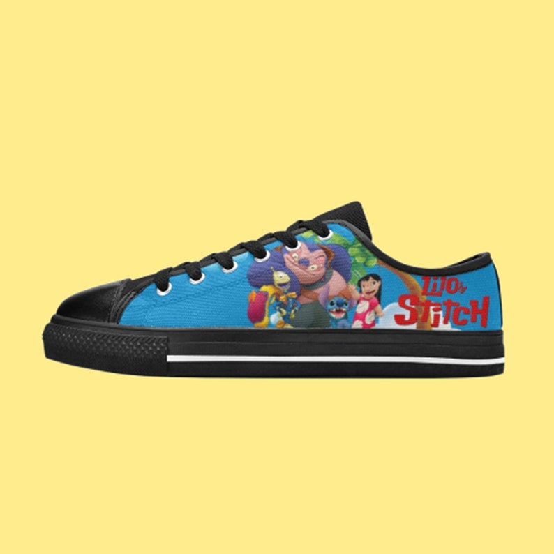 May include: Black and blue low-top canvas shoes with a graphic print of the characters from the Disney movie Lilo & Stitch. The text "Lilo & Stitch" is printed on the side of the shoe.