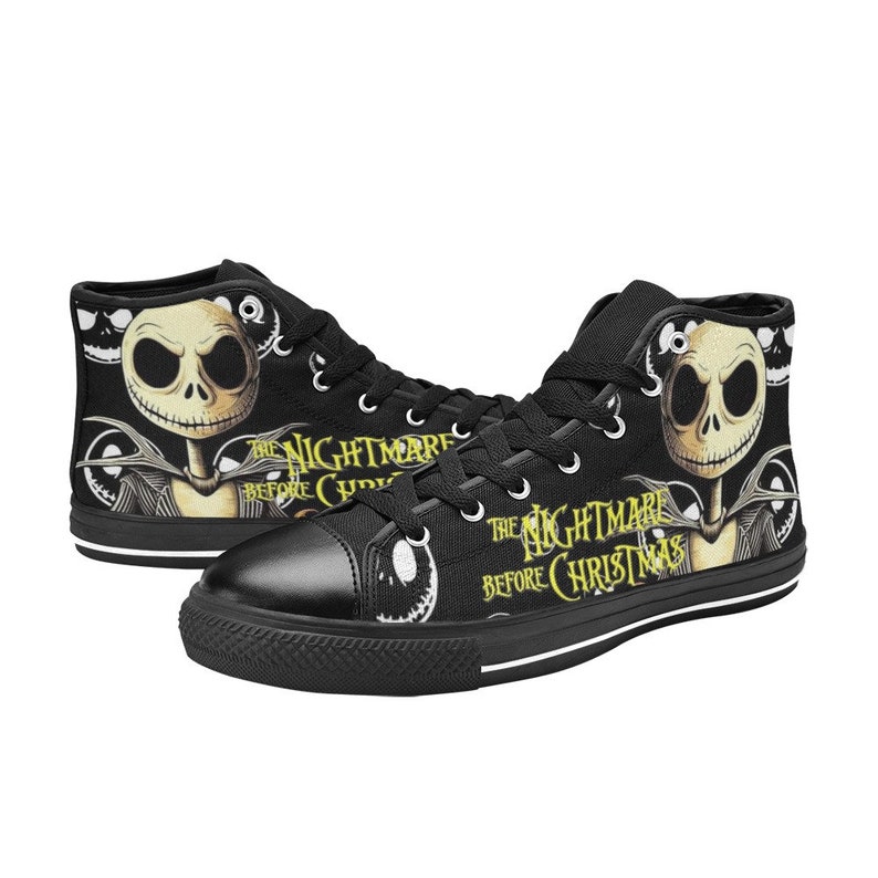 May include: Black high-top canvas sneakers featuring a design from "The Nightmare Before Christmas." The shoes display Jack Skellington's face and the movie title in yellow. The sneakers have black laces and a white sole.