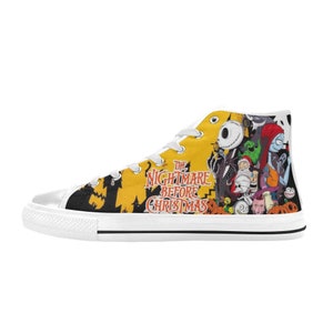 May include: High-top canvas sneaker featuring a colorful design from "The Nightmare Before Christmas." The shoe has a white sole, white laces, and a yellow background with black silhouettes and character illustrations. The text "The Nightmare Before Christmas" is also visible.