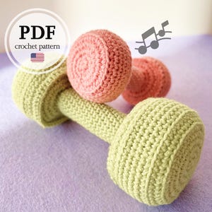 May include: A crochet pattern for a pair of pink and green dumbbells. The pattern is available as a PDF download.