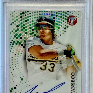 May include: A baseball card featuring Jose Canseco, a former Major League Baseball player. The card is from the 2022 Topps Pristine Jose Canseco Pristine Autographs series. The card is graded GEM MT 10 by PSA. The card features a photo of Canseco in a baseball uniform, with his signature on the card. The card is surrounded by a green and white dotted background.