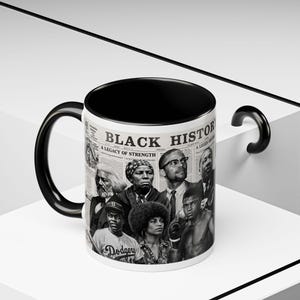 Peut inclure: Un mug en céramique blanche avec un intérieur et une anse noirs, orné d'un imprimé en noir et blanc style journal intitulé Black History. Le design présente des portraits de personnages historiques, dont un joueur de baseball en maillot Dodgers.
