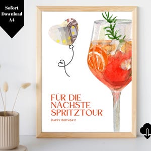 May include: A printable birthday card featuring a watercolour illustration of a glass of Aperol Spritz and a heart-shaped balloon made of money. The text on the card reads "FÜR DIE NÄCHSTE SPRITZTOUR HAPPY BIRTHDAY!"