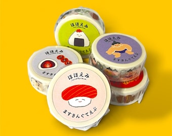 May include: A collection of five round washi tape rolls featuring Japanese-inspired illustrations including sushi, a sumo wrestler, and onigiri. Each roll is wrapped in clear plastic and displays the text "ほほえみ" and "ますきんぐてえぷ".