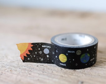 May include: A roll of black washi tape featuring a space theme with illustrations of the sun, stars, and planets including Mercury, Venus, the moon, and Earth. The text labels for Mercury, Venus, moon, and earth are printed next to each celestial body.