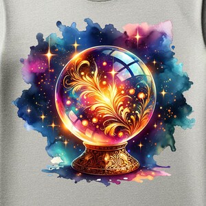 Puede incluir: Una camiseta gris claro con un diseño de acuarela colorido de una bola de cristal sobre una base dorada. La bola de cristal tiene un diseño floral en el interior. El texto "PNG File Only" está en la parte superior. El texto "Please note, this is a digital item - no physical product will be shipped." está en la parte inferior.