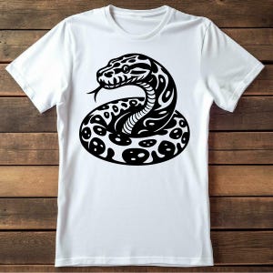 May include: White t-shirt with a black and white graphic of a snake coiled up.