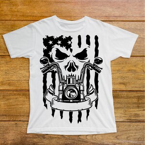 May include: White t-shirt with a black and white graphic of a skull with a motorcycle engine and handlebars. The skull is in front of an American flag.