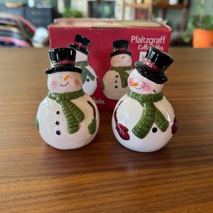 Adicione um pouco de alegria natalina à sua mesa com estes saleiros e pimenteiros de inverno em forma de boneco de neve de Natal da Pfaltzgraff Collectibles.