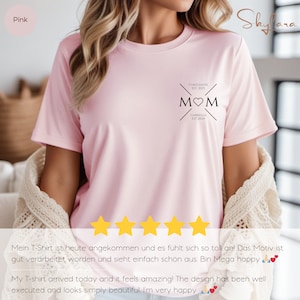 May include: Pink t-shirt with a black graphic that says "MOM" with a heart in the middle. The graphic also includes the names "Constantin" and "Gabriella" with their respective establishment years.