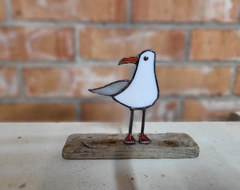 Stained glass seagulls on driftwood.
