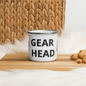 May include: White enamel camping mug with black text that reads "GEAR HEAD".