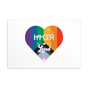 Op de afbeelding: Een witte rechthoekige print met een hartvormig ontwerp met een regenboogverloop. Het hart bevat de tekst "HrGR Loved" in het wit, met veer- en pijlaccenten. De onderkant van het hart toont verschillende kleuren van de pride-vlag.