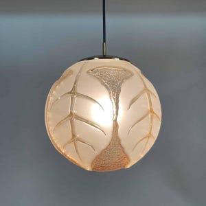 Può includere: Una lampada a sospensione in vetro bianco con un design a foglia. La luce è rotonda e ha una finitura in ottone.